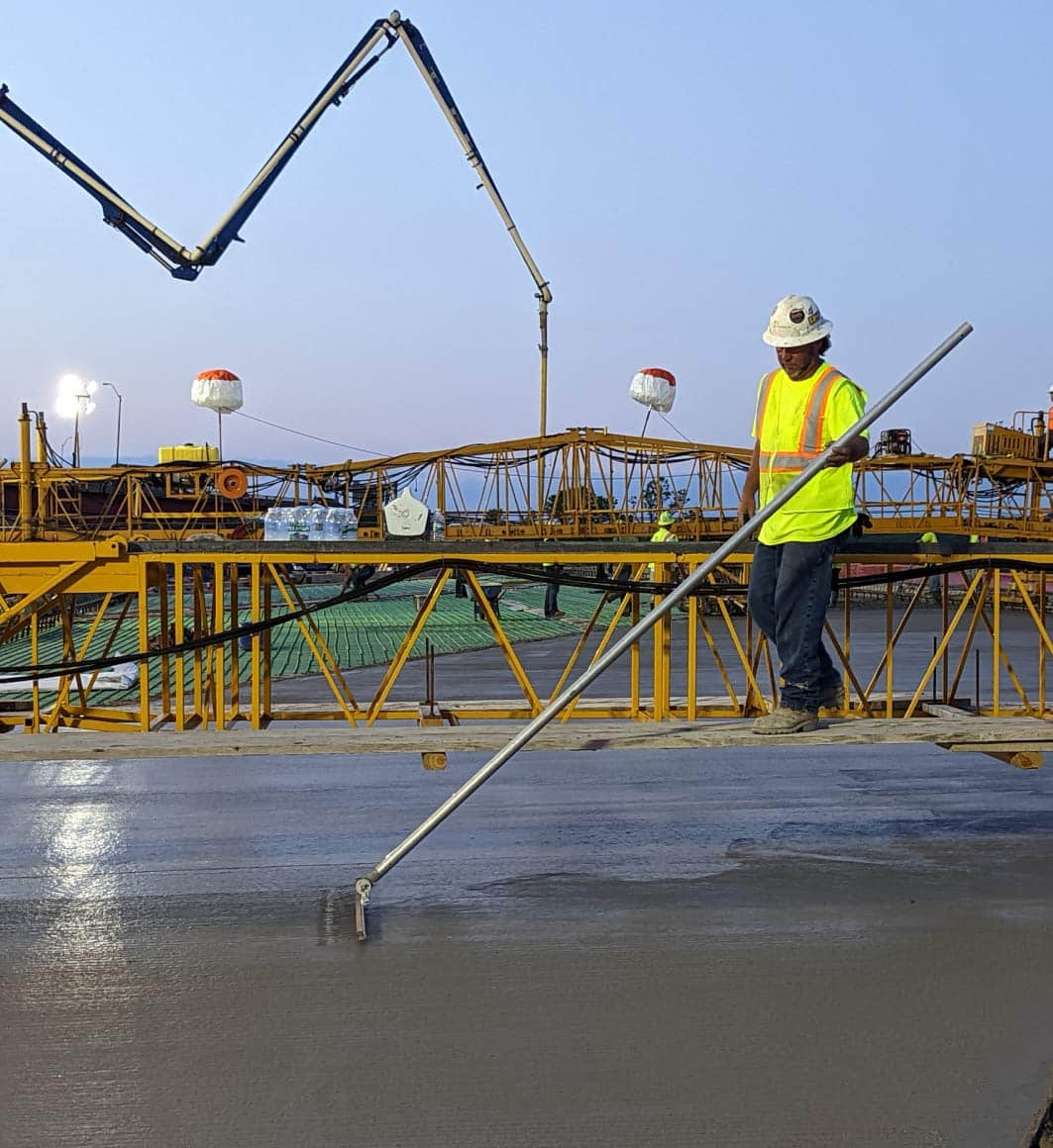 construction worker smoothing concrete on job site