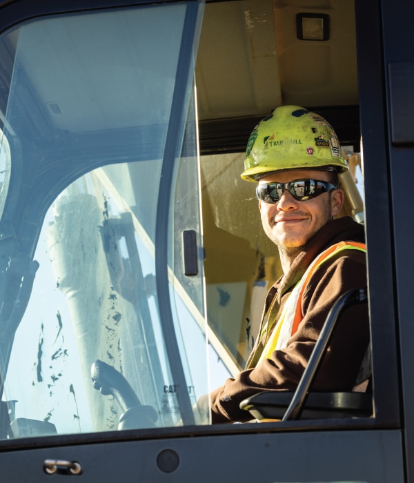 construction worker smiling in excavator cab