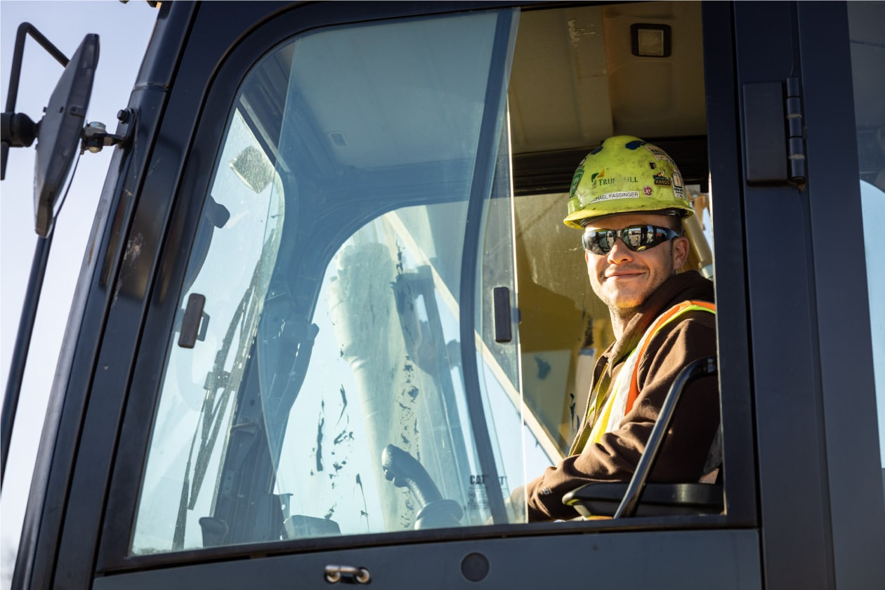 construction worker smiling while using machiney